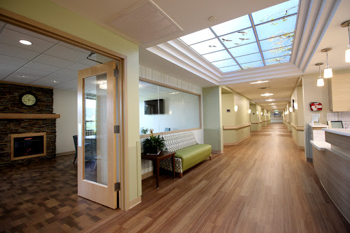A well-lit hospital corridor featuring a waiting area with modern furniture.