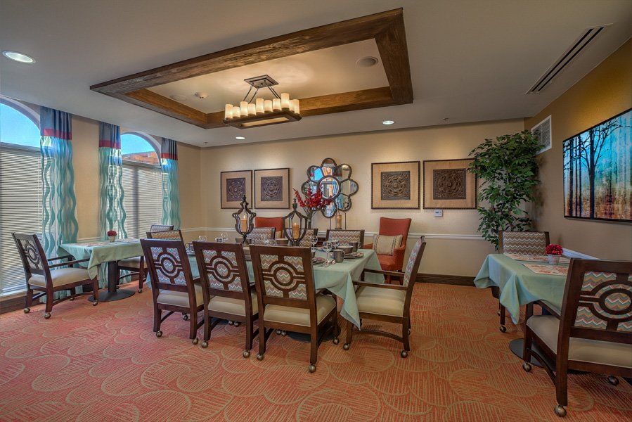 A well-decorated dining room featuring an elegant table and chairs, complemented by a chandelier and wall artwork.
