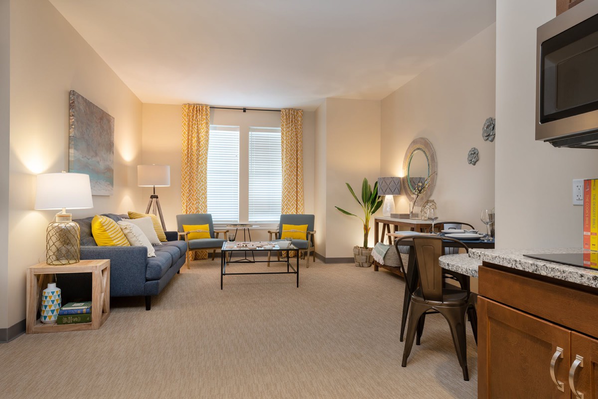 A cozy living room featuring modern decor with a sofa, coffee table, and various decorative elements.