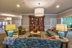 Cozy living room with patterned sofas, chairs, and a wooden cabinet.