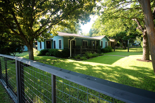 A cozy house surrounded by lush greenery and a well-maintained lawn.