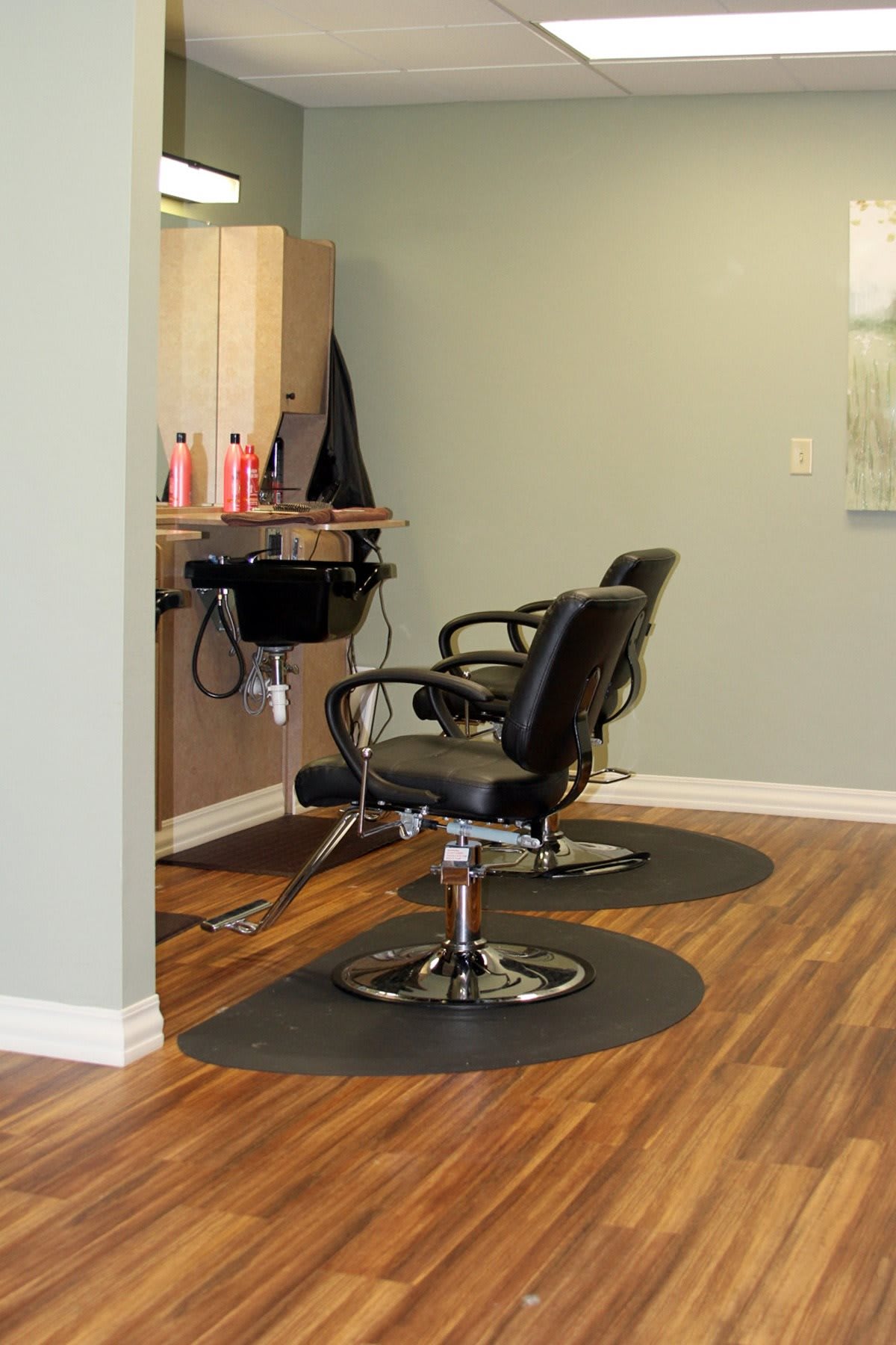 Interior of a hair salon with two empty barber chairs.