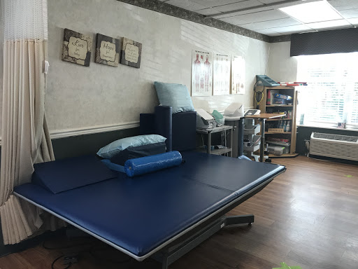 A therapy room equipped with blue mats and various rehabilitation tools, designed for a calming and supportive atmosphere.