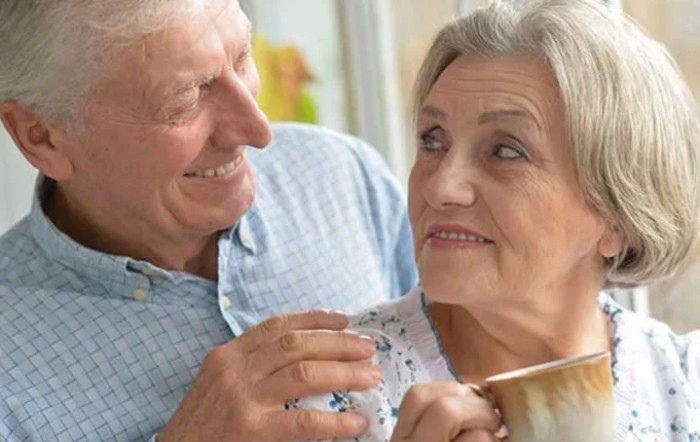 An elderly couple enjoying a warm moment together at home.
