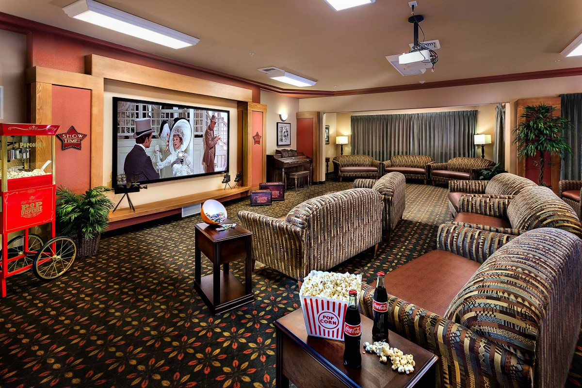 Cozy home theater setup with a large screen and comfortable seating, complete with popcorn and drinks for a perfect movie night.