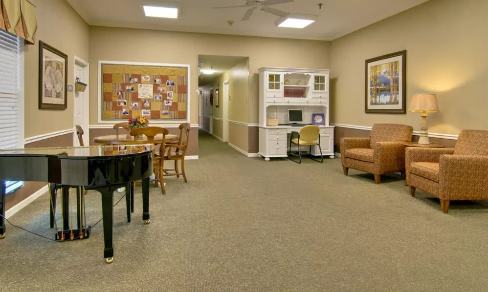 A cozy room with a piano, furniture, and warm lighting.