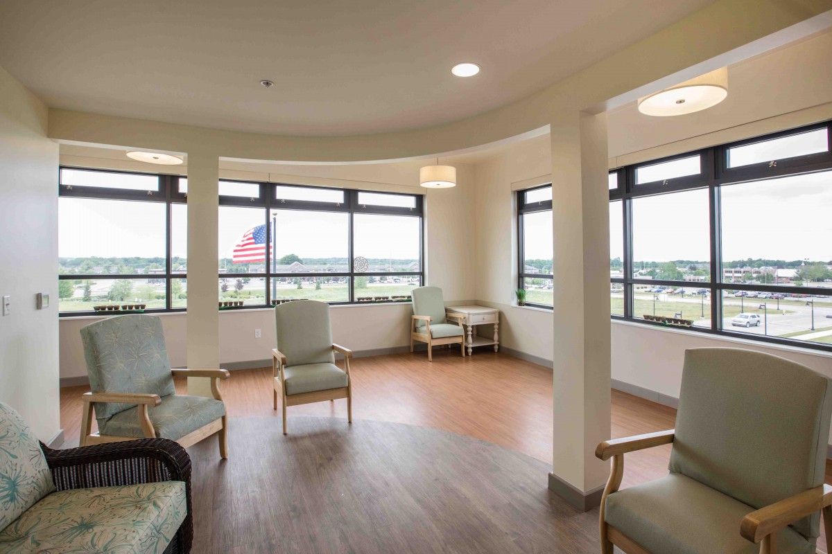 A bright and spacious waiting room with several chairs arranged around large windows, allowing natural light to fill the space.