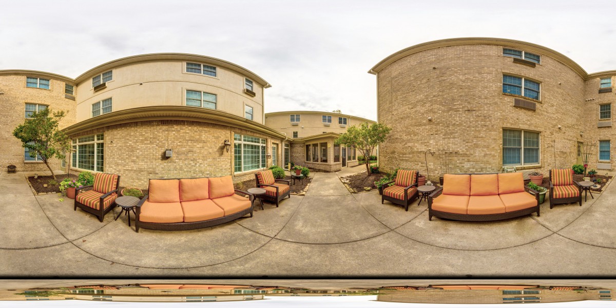 A spacious outdoor patio with comfortable seating in a courtyard setting.