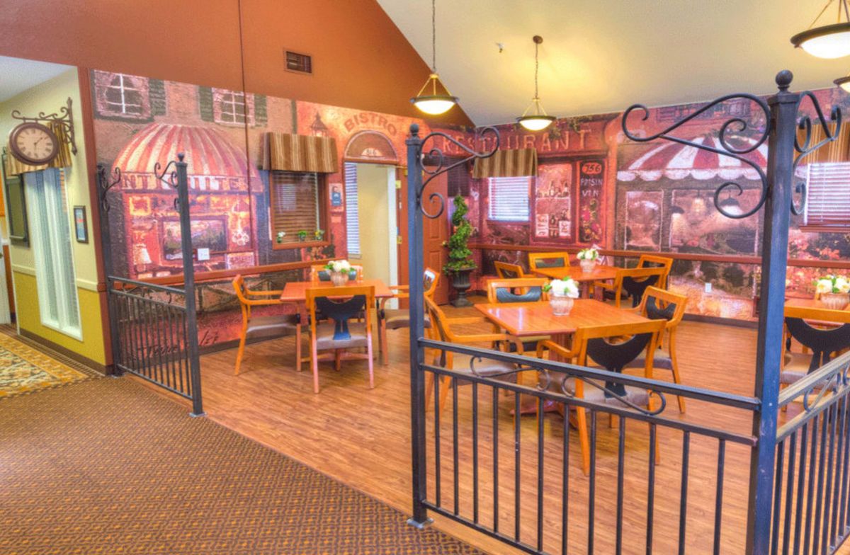 A cozy indoor cafe with decorative wall art and neatly arranged tables and chairs.