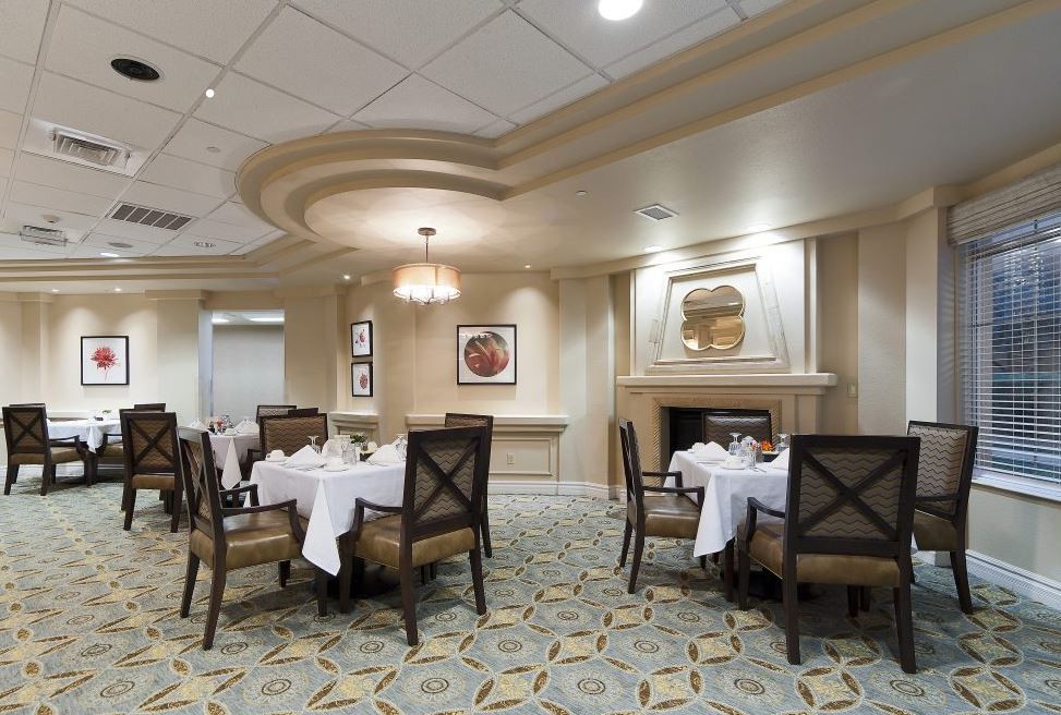 An elegant dining room with neatly arranged tables and chairs, featuring tasteful decor and soft lighting.
