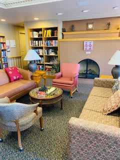 A cozy living room with comfortable sofas, bookshelves, and a fireplace.