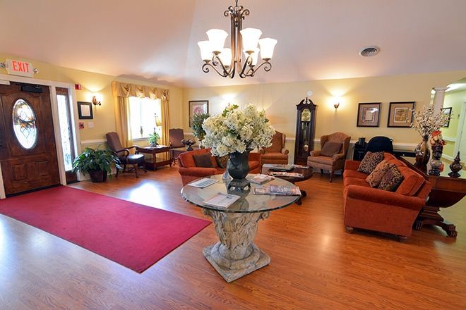 A cozy and elegantly decorated living room with a central table featuring a floral arrangement and comfortable seating.