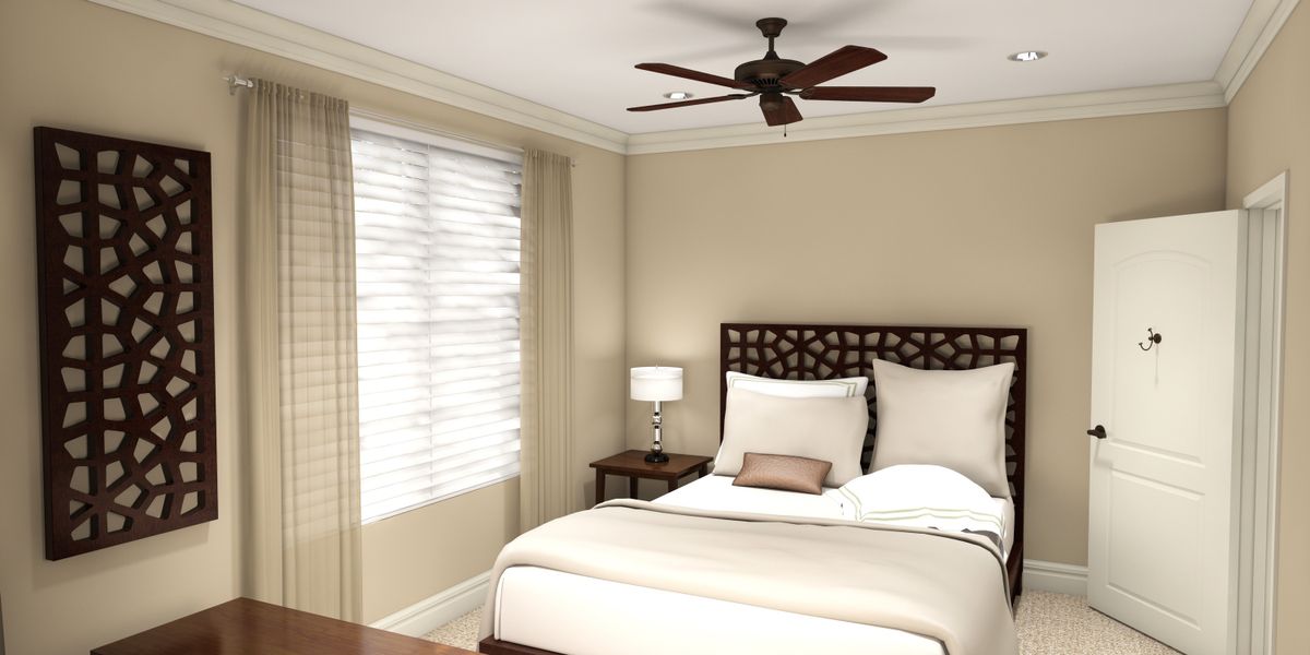 A cozy bedroom with a ceiling fan, bed, and a lamp by the window.