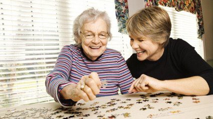 Two women enjoying a puzzle together.