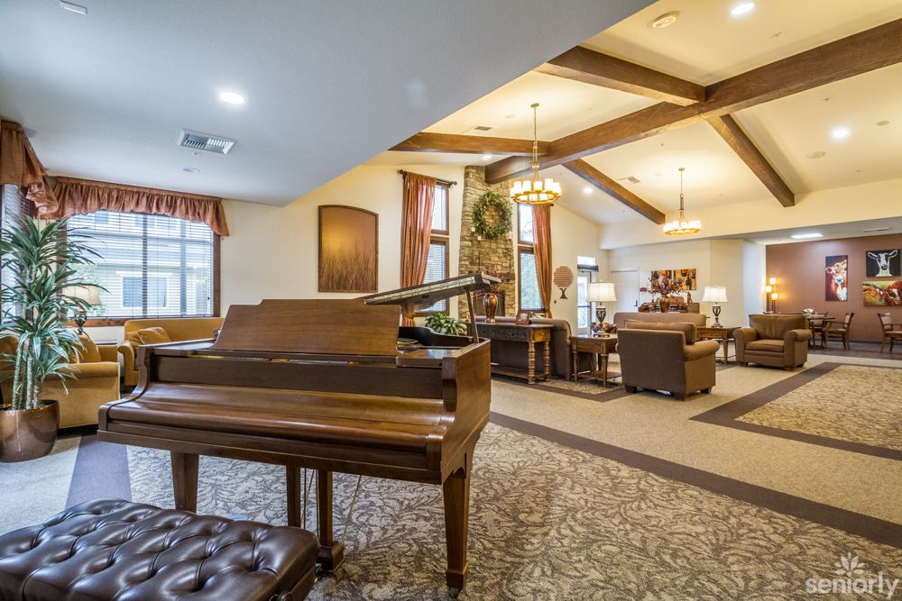 A spacious living room with a grand piano and elegant interior design.