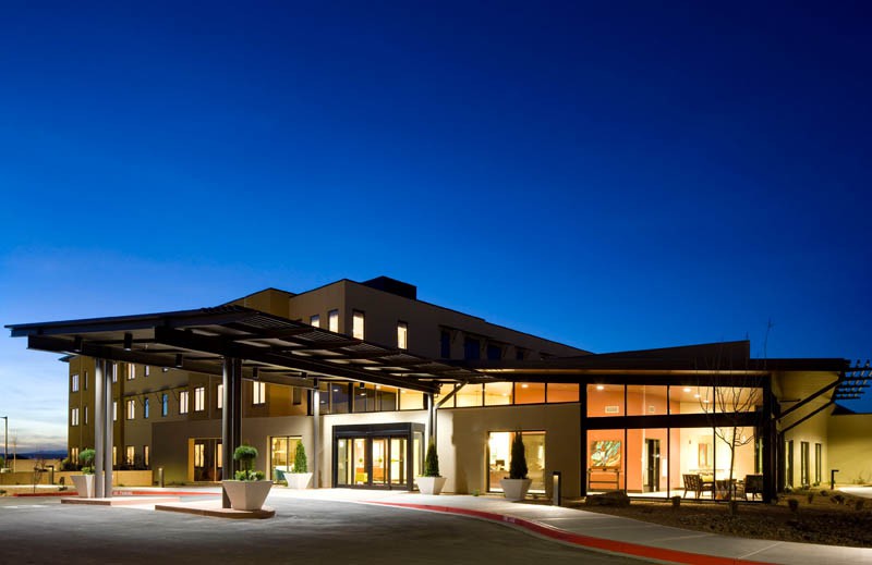A modern hotel exterior illuminated at night.