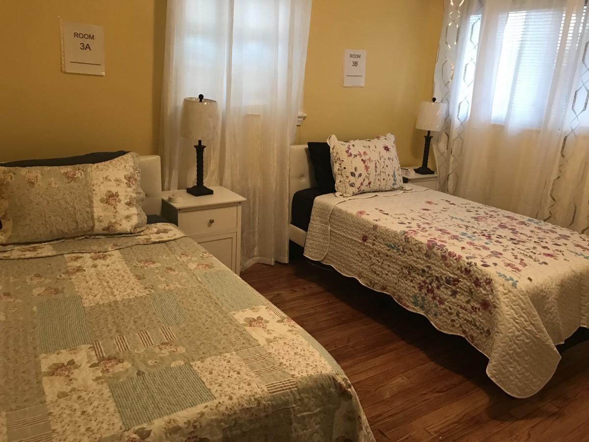 A cozy bedroom with twin beds and soft lighting.