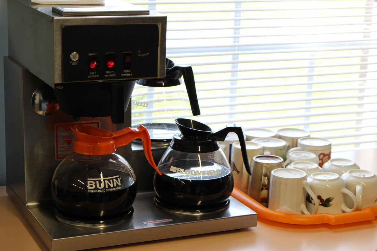 A coffee maker with two glass coffee pots ready to serve.