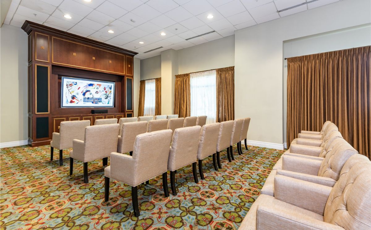 A neatly arranged meeting room with rows of chairs facing a presentation screen.