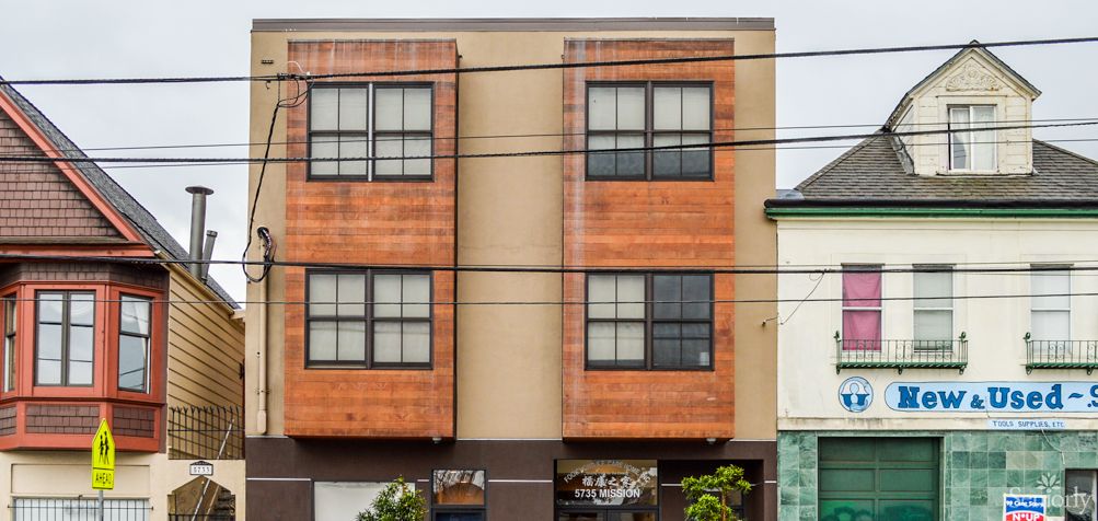 A modern urban apartment building with a distinctive facade featuring large windows.