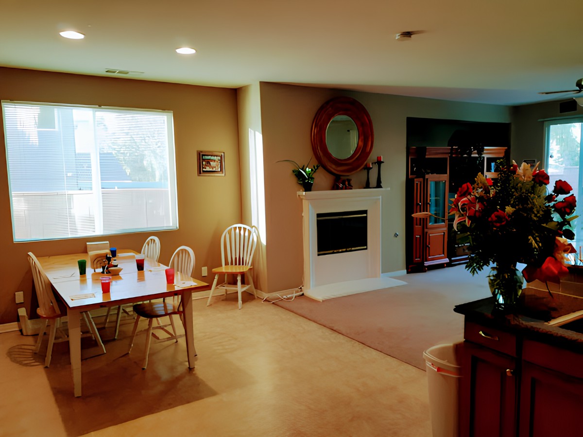 A cozy dining and living area featuring a dining table with chairs and a fireplace.