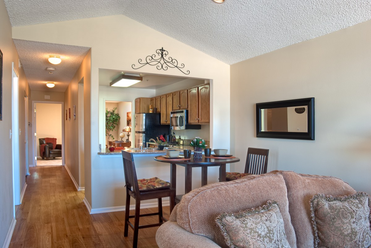 A cozy living room and kitchen area with modern furniture and decor.