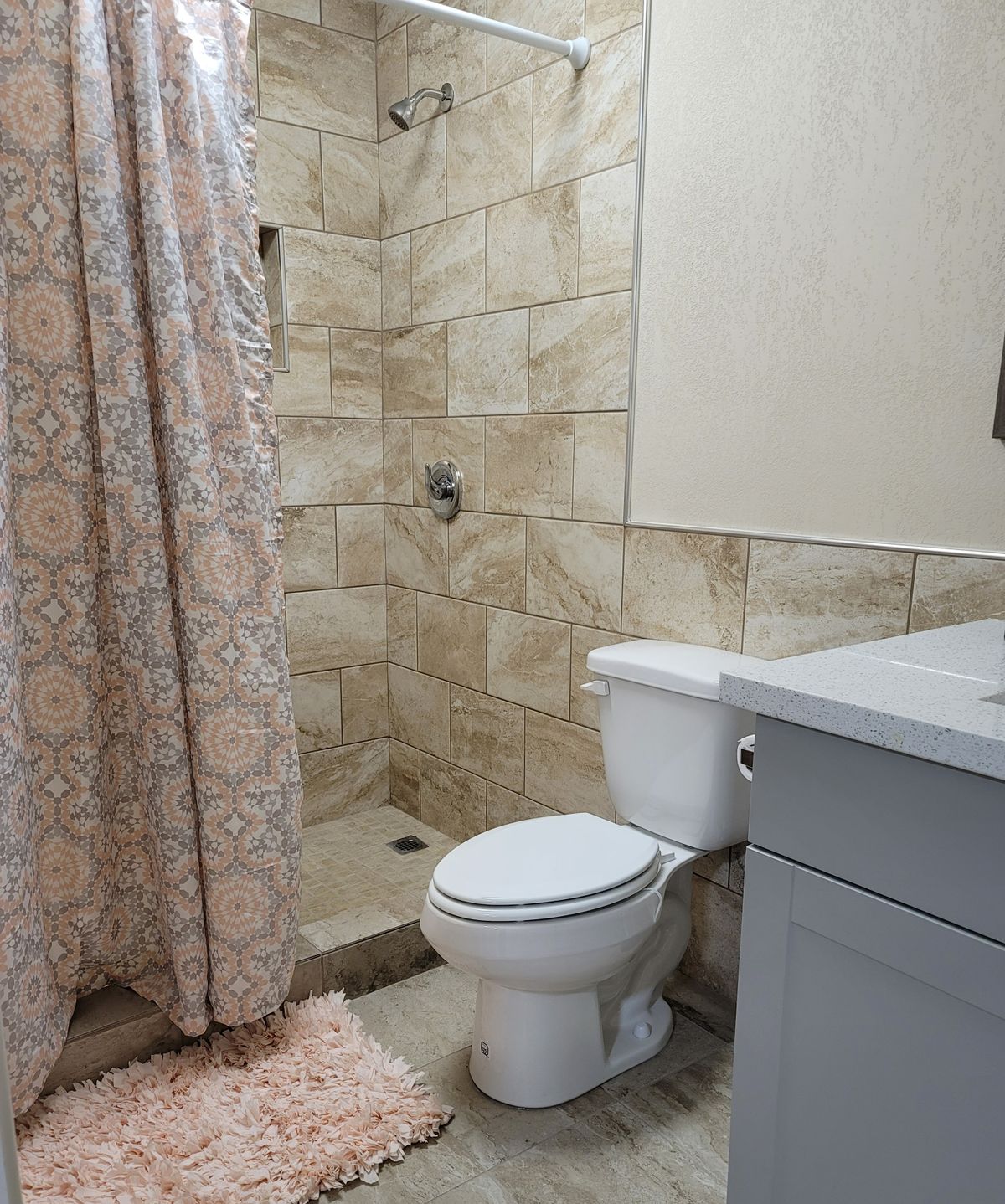 A modern bathroom with a shower, toilet, and sink.