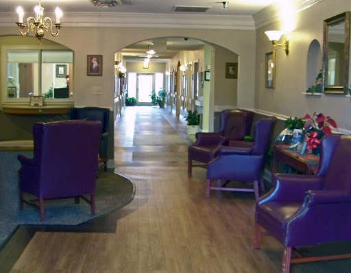 A welcoming lobby featuring purple seating and a wooden floor, designed for comfort and relaxation.