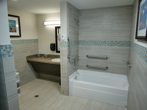 A modern and accessible bathroom featuring a bathtub and sink, designed for convenience and style.