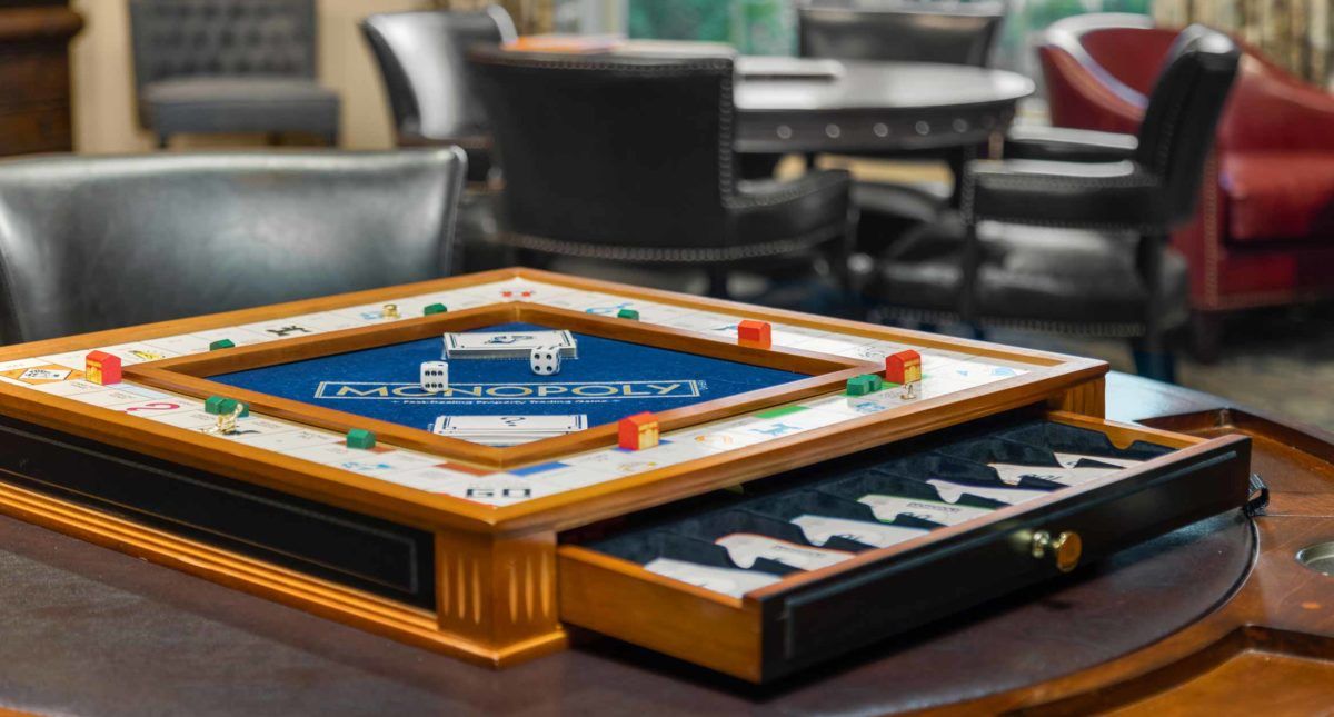 A backgammon set with dice and game pieces arranged on a table in a cozy indoor setting.