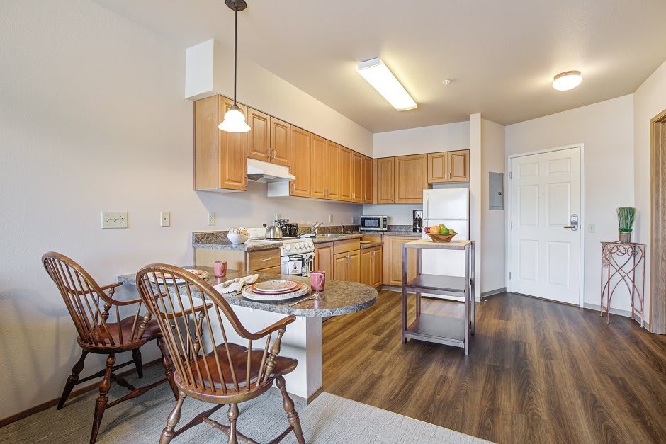 A modern kitchen with wooden cabinets and a cozy dining area.