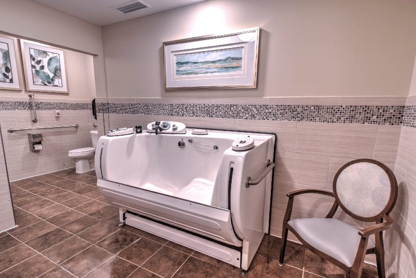 A well-designed bathroom featuring a modern bathtub, tiled flooring, and decorative artwork on the wall.