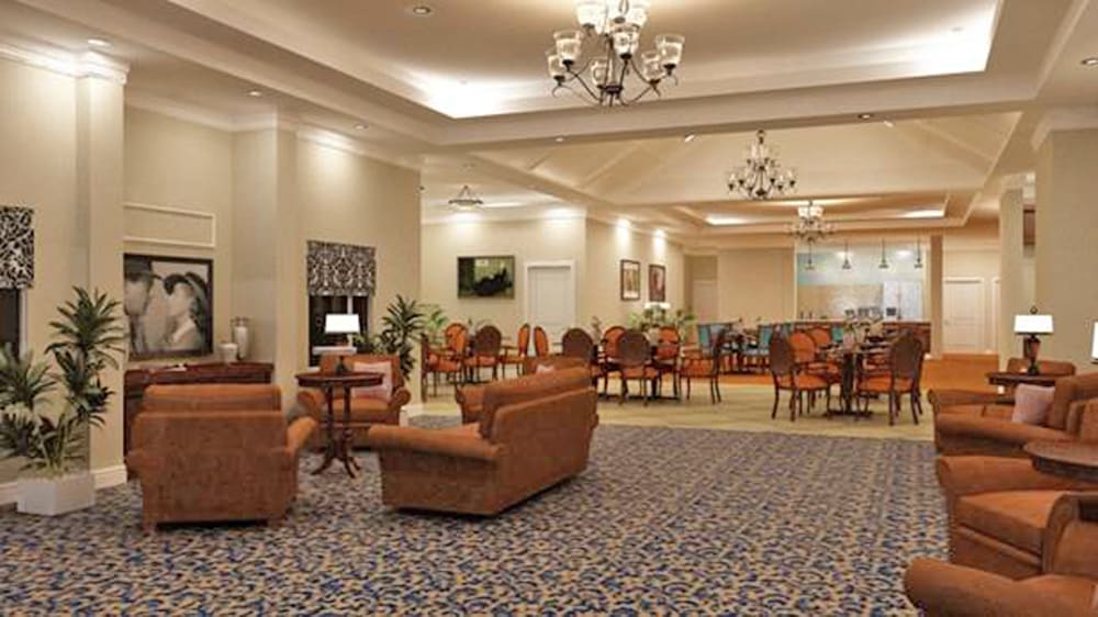 A spacious and elegantly decorated lobby with comfortable seating and chandeliers.