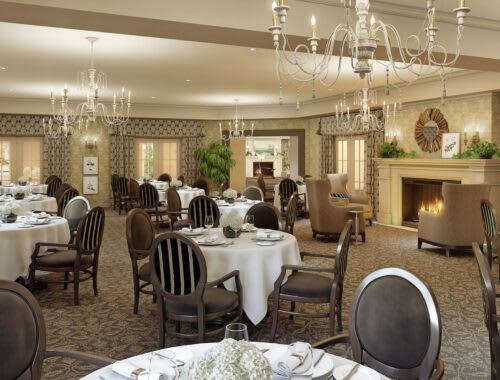 An elegant dining room with beautifully set tables and chandeliers.