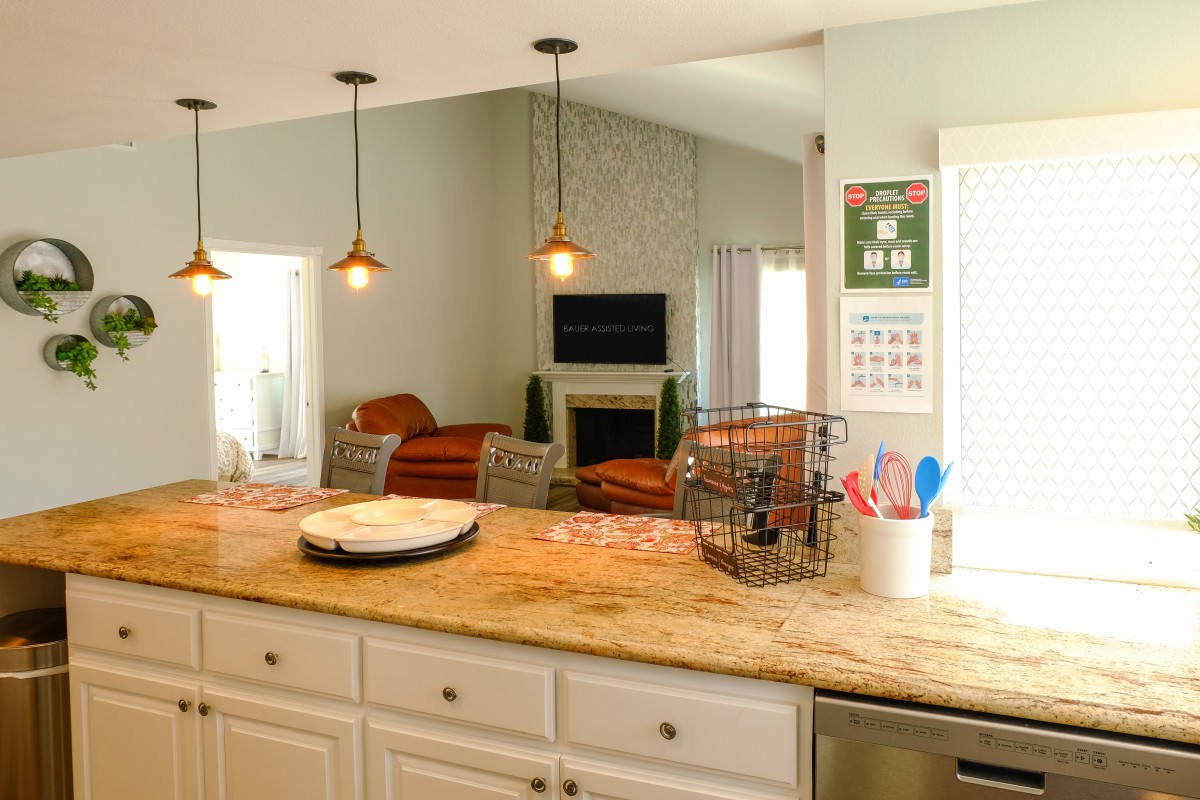 A cozy kitchen with a granite countertop and view into the living area.