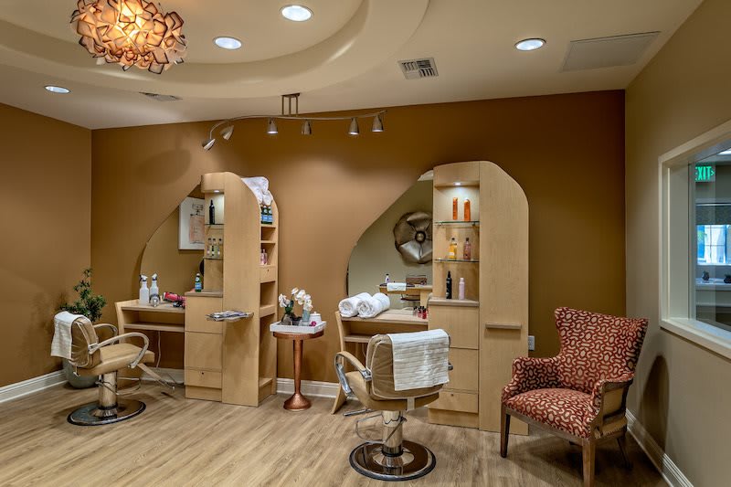 A cozy and stylish salon interior with hairdressing stations, mirrors, and comfortable seating.
