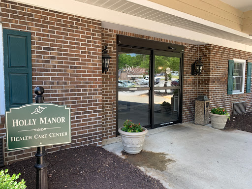 The entrance to a manor, featuring a brick facade and decorative planters.