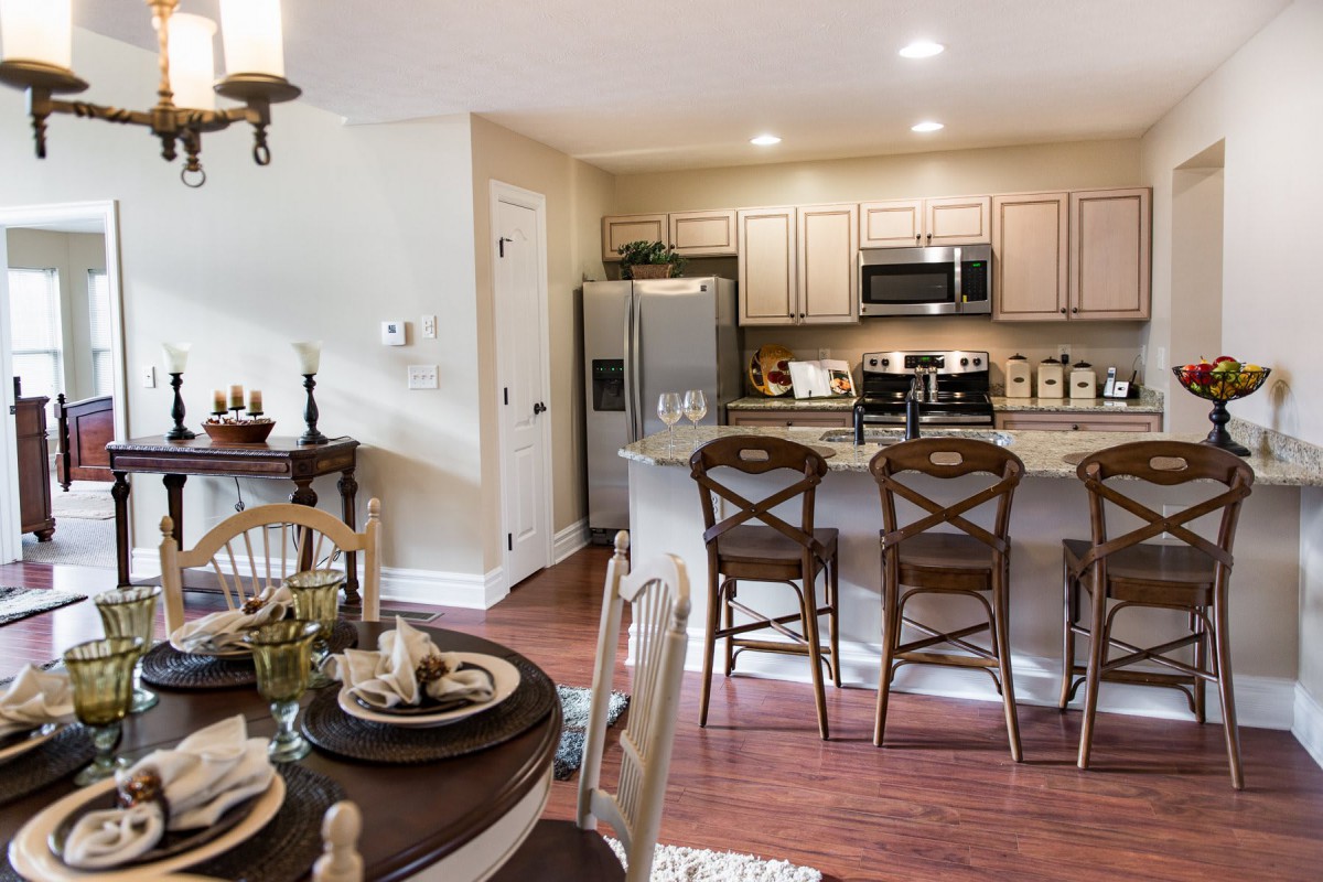 A modern kitchen with an open dining area featuring a kitchen island and elegant decor.
