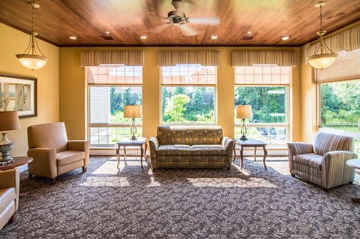 A cozy living room filled with natural light, featuring comfortable seating and a warm ambiance.