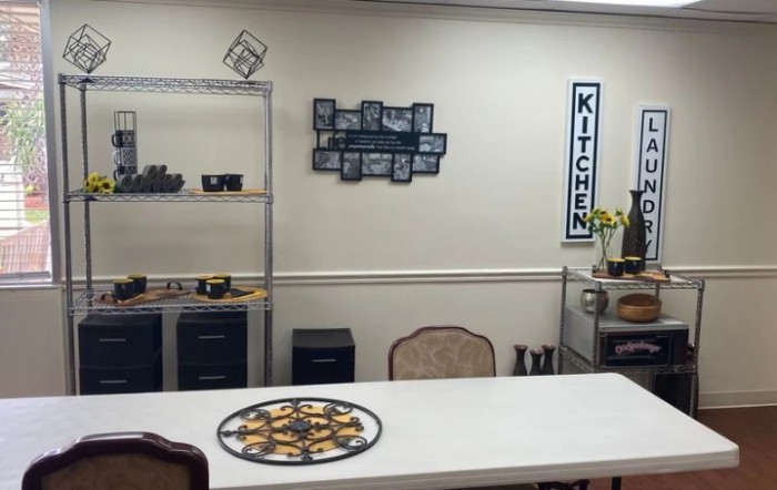 A cozy kitchen area with a table and decorative shelves.