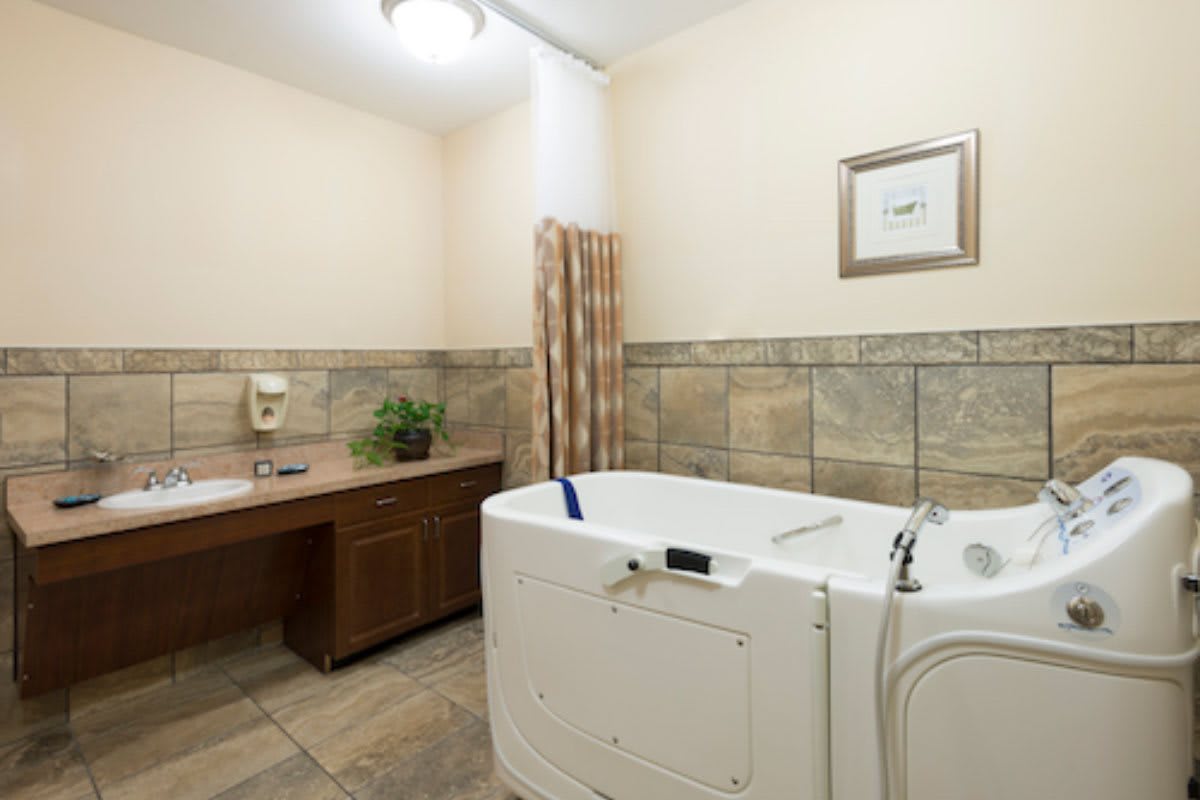 A clean and modern bathroom with a walk-in bathtub and tiled walls.