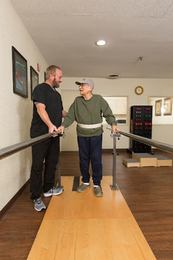 A therapist assists an elderly patient during a physical therapy session, promoting mobility and independence.