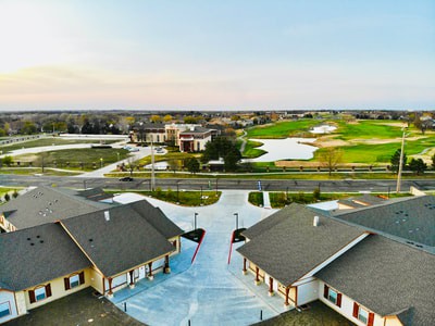Aerial view of a suburban neighborhood with houses and a nearby golf course.