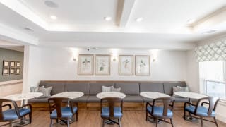 A minimalist cafe interior with tables, chairs, and wall art.