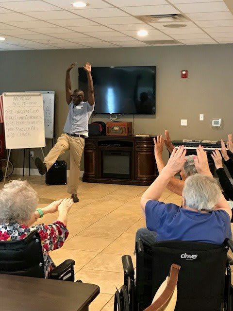 A fitness instructor leads a group of seniors in an exercise class.