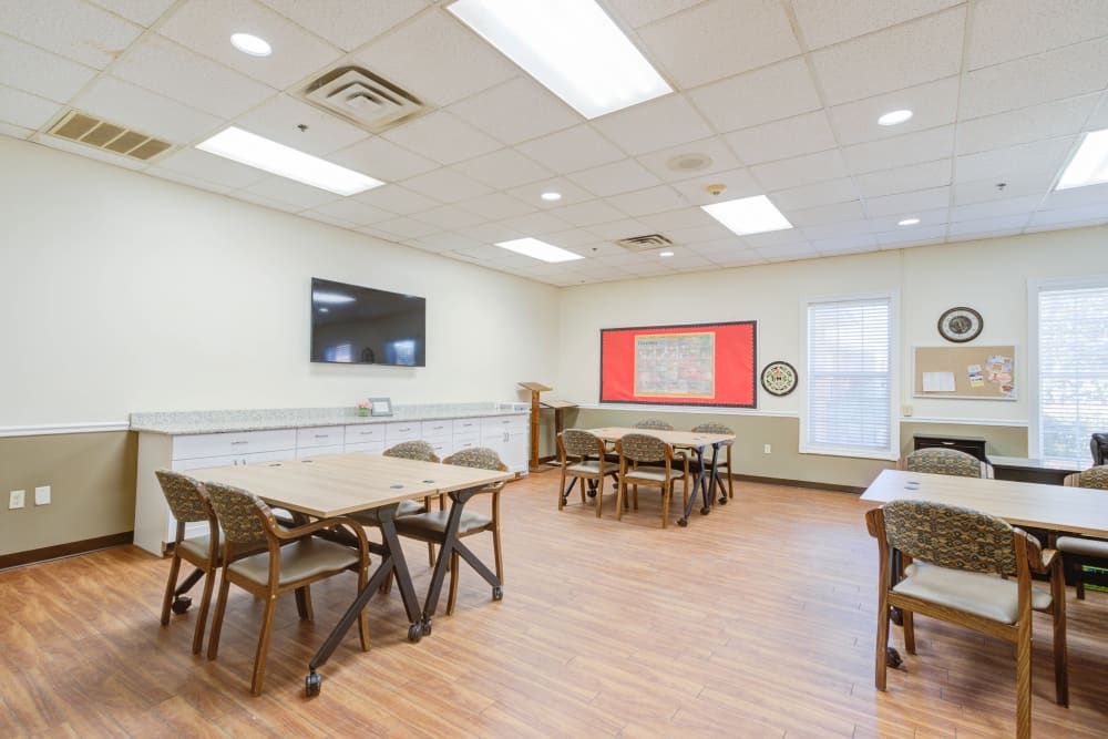A well-lit classroom with tables and chairs arranged for learning.