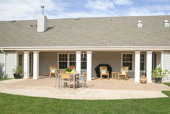 A backyard patio with outdoor furniture and a well-maintained lawn.