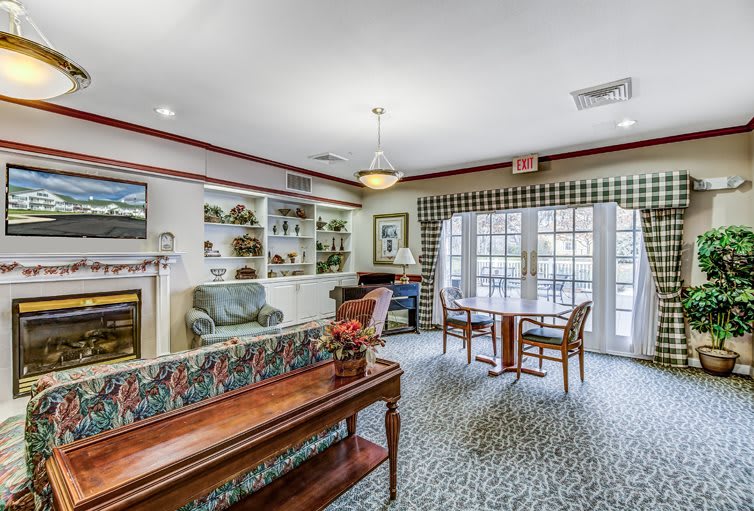 A cozy living room with comfortable seating, elegant furnishings, and ample natural light streaming through large windows.