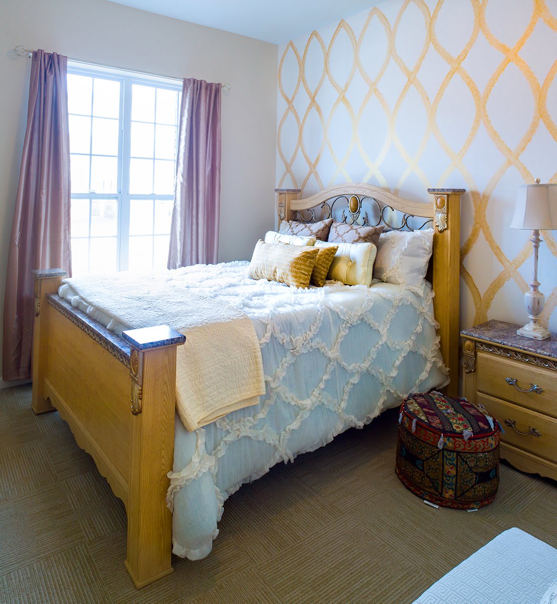 A cozy bedroom with wooden furniture and decorative pillows.