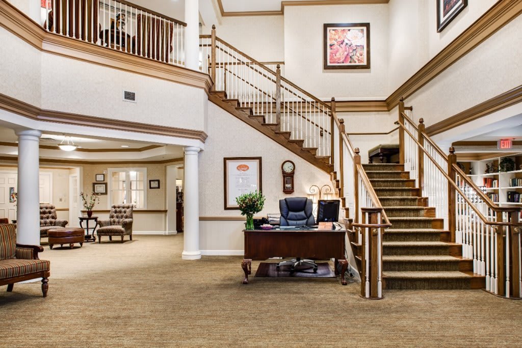 A spacious lobby area with a reception desk and a grand staircase.